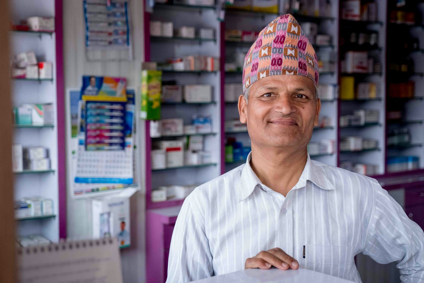 Man in pharmacy smiles behind the counter.